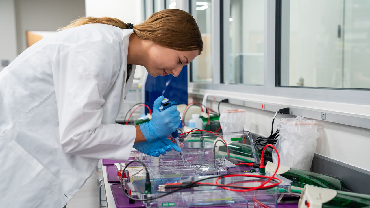 A scientist pipetting from a tube